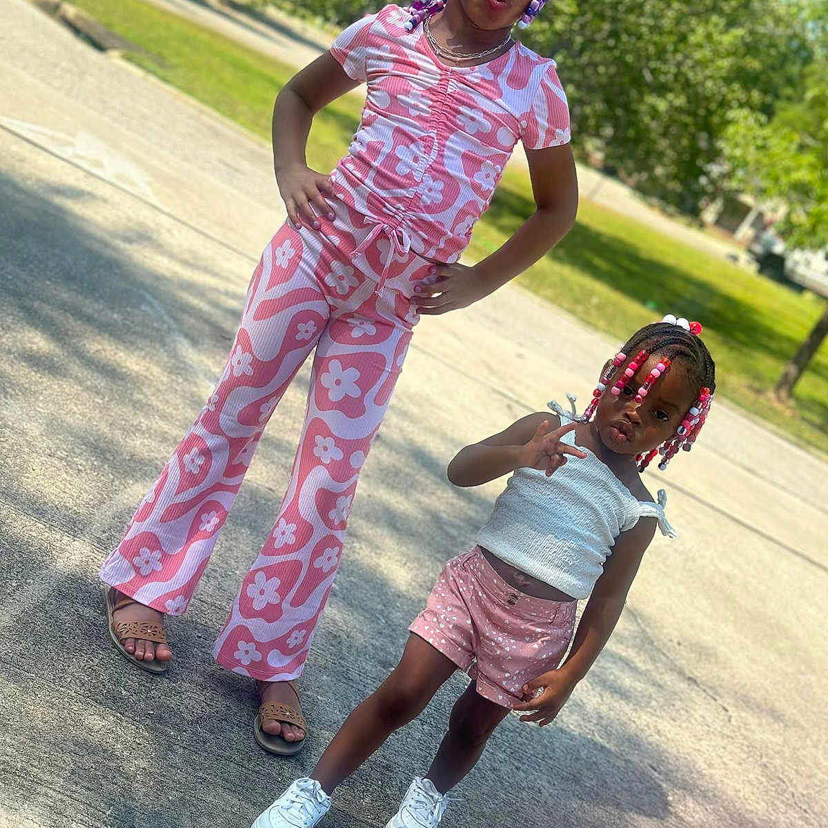 Elanii is registered to the contest to win money with this photo: beads, braids, child, children, colorful_clothing, confident, fashion, greenery, happy, outdoor, playful, portrait, posing, sandals, shorts, sidewalk, sneakers, summer, sunlight, tshirt