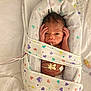 newborn, baby, blanket, hospital, medical_equipment, wires, sensor, face, infant, swaddled, bed, healthcare, cute, heart_pattern, person, lying_down, small, wrapped, skin, resting