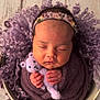 Hallie joined the competition — help win amazing prizes! baby, sleeping, newborn, purple, knitwear, teddy_bear, headband, floral, curly_background, wrapped, peaceful, cute, infant, portrait, soft_texture, hands, closed_eyes, cozy, small, child