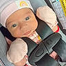 baby, infant, car_seat, hat, mittens, pink_clothing, rainbow_patch, straps, safety, child, cute, young, portrait, seatbelt, adorable, face, expression, newborn, indoor, closeup