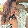 woman, dog, car, affection, kiss, polka_dot, fringe_top, spotted_dog, pet, inside_vehicle, casual_clothing, love, outdoor_view, seat, head, tongue, close_up, interaction, human_animal_bond, happy
