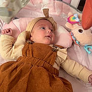 Rose a rejoint le concours — aidez-le/la à gagner de superbes lots ! baby, bedroom, child, clothing, comfort, corduroy, crib, cushion, cute, dress, floor, gaze, headband, indoor, infant, person, pink, plush_toy, portrait, soft_toy