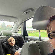Jennika is registered to the contest to win money with this photo: adult, baby, backseat, car, car_seat, child, duck_toy, family_trip, happy, infant, outdoor, passenger, portrait, seatbelt, sitting, smiling, sunglasses, toy, vehicle, window