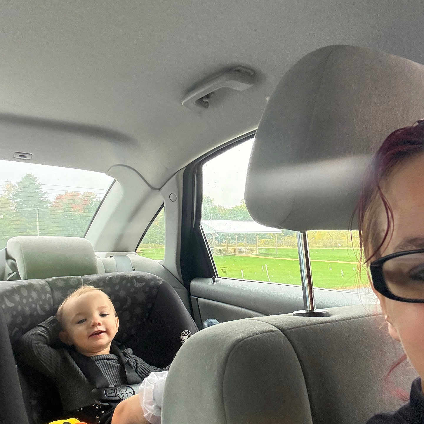 Jennika is registered to the contest to win money with this photo: adult, baby, backseat, car, car_seat, child, duck_toy, family_trip, happy, infant, outdoor, passenger, portrait, seatbelt, sitting, smiling, sunglasses, toy, vehicle, window