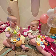 Esme And Lola is registered to the contest to win money with this photo: baby, balloons, birthday, carpet, celebration, child, crown_balloon, doll, gift_wrap, happy, indoor, number_one_balloon, onesie, pink, playful, present, purple, sitting, smiling, toys