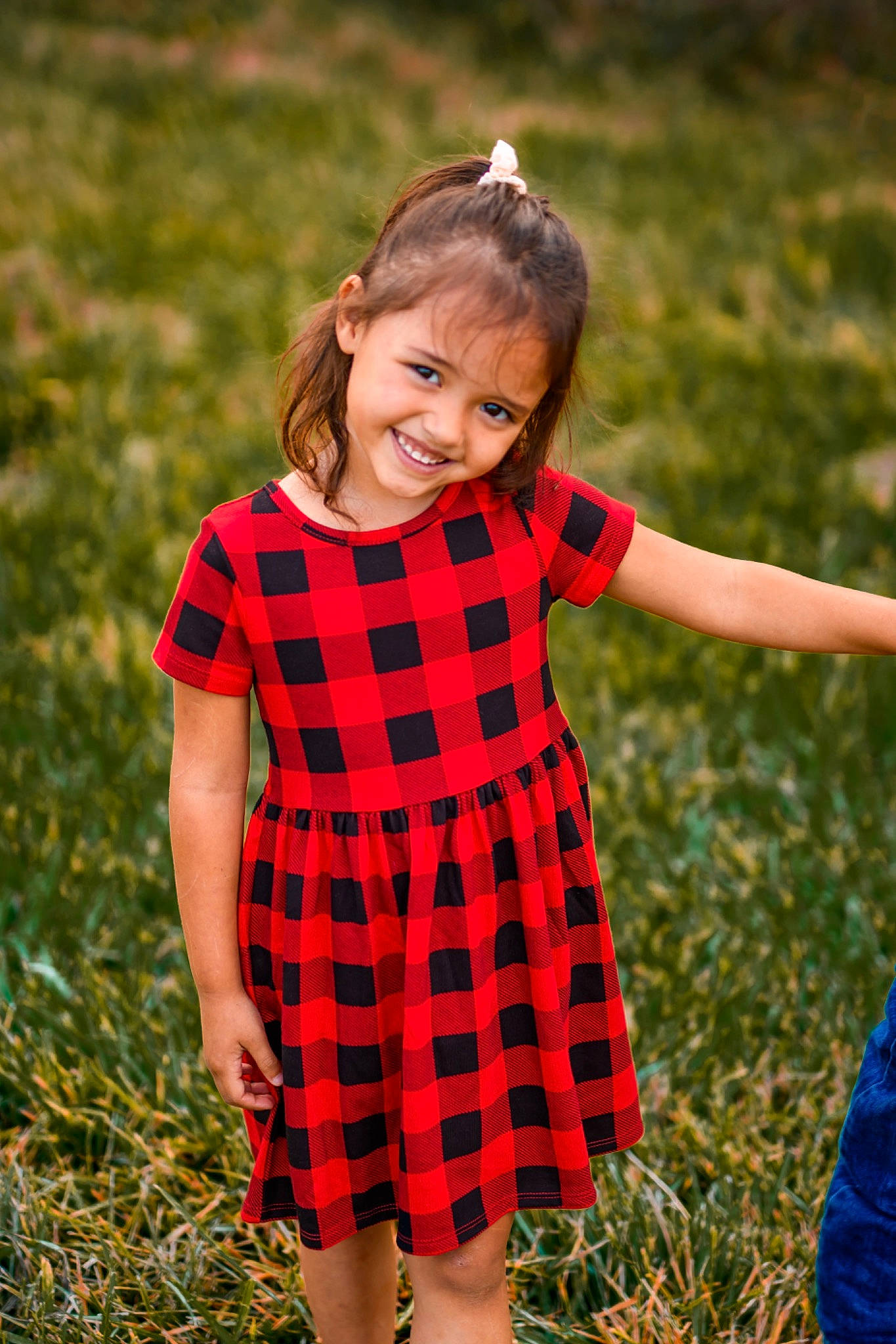 Kaili is registered to the contest to win money with this photo: blond, child, day_dress, dress, face, gesture, grass, grassland, happy, head, joy, one_piece_garment, pattern, people_in_nature, person, plaid, plant, sleeve, smile, tartan