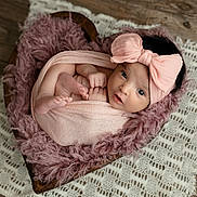 Aurora is registered to the contest to win money with this photo: baby, infant, newborn, pink_bow, wrapped, wooden_bowl, heart_shaped, fluffy_fabric, crocheted_mat, wooden_floor, cute, portrait, indoors, soft_texture, cozy, tiny_toes, curious_eyes, headwear, wrapped_in_cloth, resting