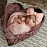 baby, infant, newborn, pink_bow, wrapped, wooden_bowl, heart_shaped, fluffy_fabric, crocheted_mat, wooden_floor, cute, portrait, indoors, soft_texture, cozy, tiny_toes, curious_eyes, headwear, wrapped_in_cloth, resting