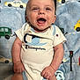 Dallas is registered to the contest to win money with this photo: baby, smiling, infant, onesie, blanket, soft_texture, blue, car_pattern, traffic_light, pacifier, clothing, cute, happy, lying_down, child, portrait, indoor, skin, hands, face