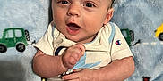 Dallas joined the competition — help win amazing prizes! baby, infant, child, blanket, blue_blanket, car_pattern, onesie, white_clothing, light_blue_trim, pacifier, happy, smiling, face, head, hands, lying_down, indoors, soft_texture, cute, portrait