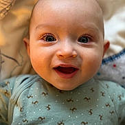 Jules participe au concours pour gagner de l'argent avec cette photo : baby, infant, smile, face, eyes, onesie, green_clothing, blanket, closeup, happy, child, cute, skin, head, person, newborn, lying_down, indoors, soft_light, expression
