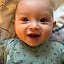 baby, infant, smile, face, eyes, onesie, green_clothing, blanket, closeup, happy, child, cute, skin, head, person, newborn, lying_down, indoors, soft_light, expression