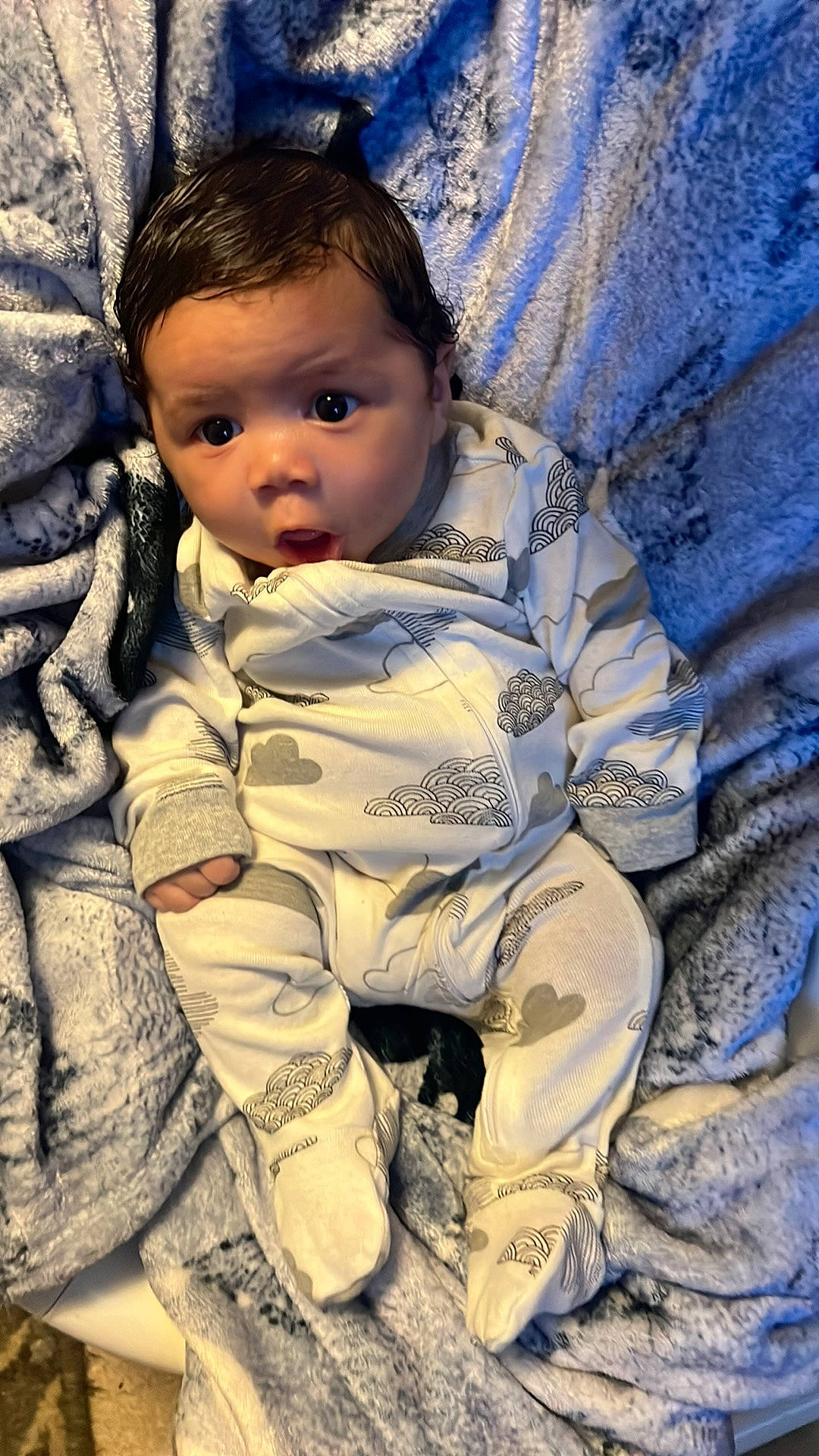 King is registered to the contest to win money with this photo: baby, baby_toddler_clothing, cheek, child, comfort, cool, eye, face, facial_expression, grass, hair, happy, head, iris, linens, nose, person, skin, sleeve, textile