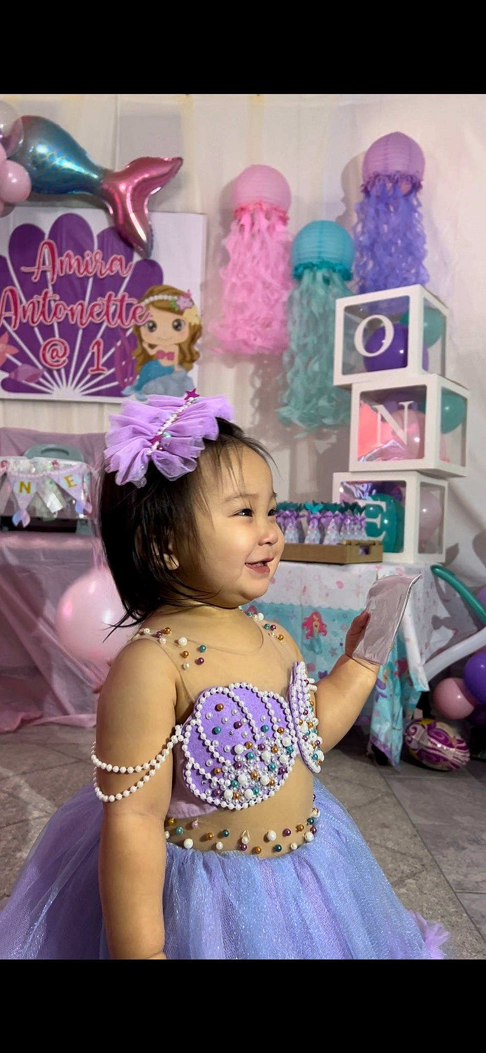 Amira is registered to the contest to win money with this photo: beauty, child, event, fashion_accessory, fun, happy, headpiece, jewellery, joy, magenta, party, party_supply, person, photograph, pink, purple, room, smile, snapshot, sweetness