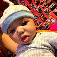 Monté is registered to the contest to win money with this photo: baby, infant, hat, cute, face, portrait, child, person, red_wall, photographs, background, curious, indoors, clothing, closeup, headwear, expression, skin, eyes, mouth