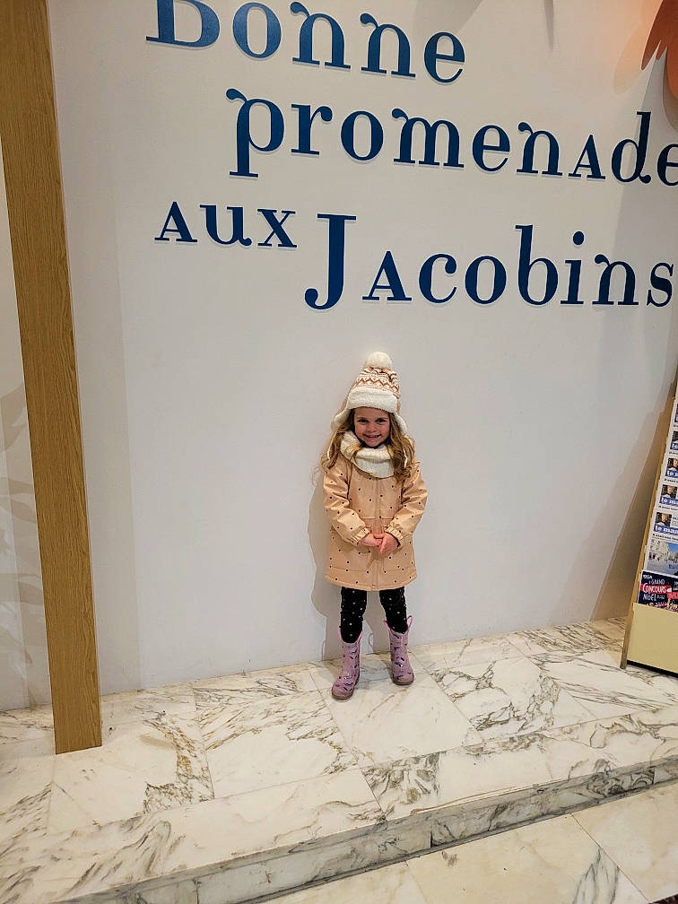 Gabriella participe au concours pour gagner de l'argent avec cette photo : advertising, banner, boot, child, denim, fashion_design, flooring, font, fur, headwear, joy, linens, pattern, person, room, scarf, sleeve, t_shirt, toddler, visual_arts