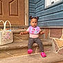 bag, bib, blue_siding, child, cute, door, fashion, hair_buns, heart_pattern, house, leggings, outdoor, person, pink_shoes, sitting, steps, stone, toddler, wall, wooden_door