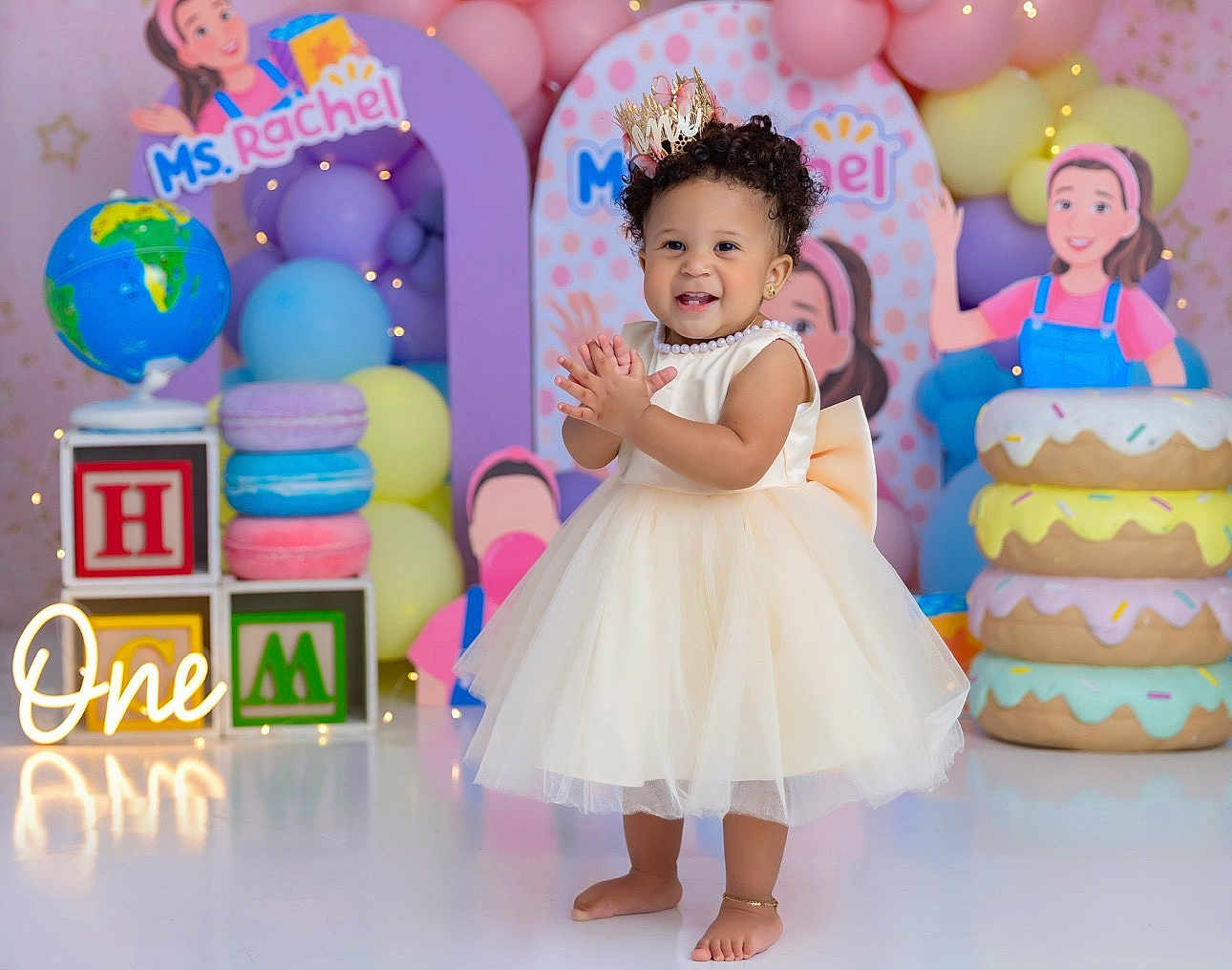 Aubree joined the competition — help win amazing prizes! toddler, child, birthday, party, dress, crown, balloons, donuts, blocks, globe, smile, clapping, celebration, pastel_colors, floor, decorations, happy, indoor, person, photography
