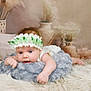 baby, infant, flower_headband, cushion, fluffy_rug, soft_texture, blue_eyes, lying_down, decorative_vase, dried_flowers, white_clothing, close_up, indoors, portrait, cute, peaceful, soft_lighting, child, newborn, resting