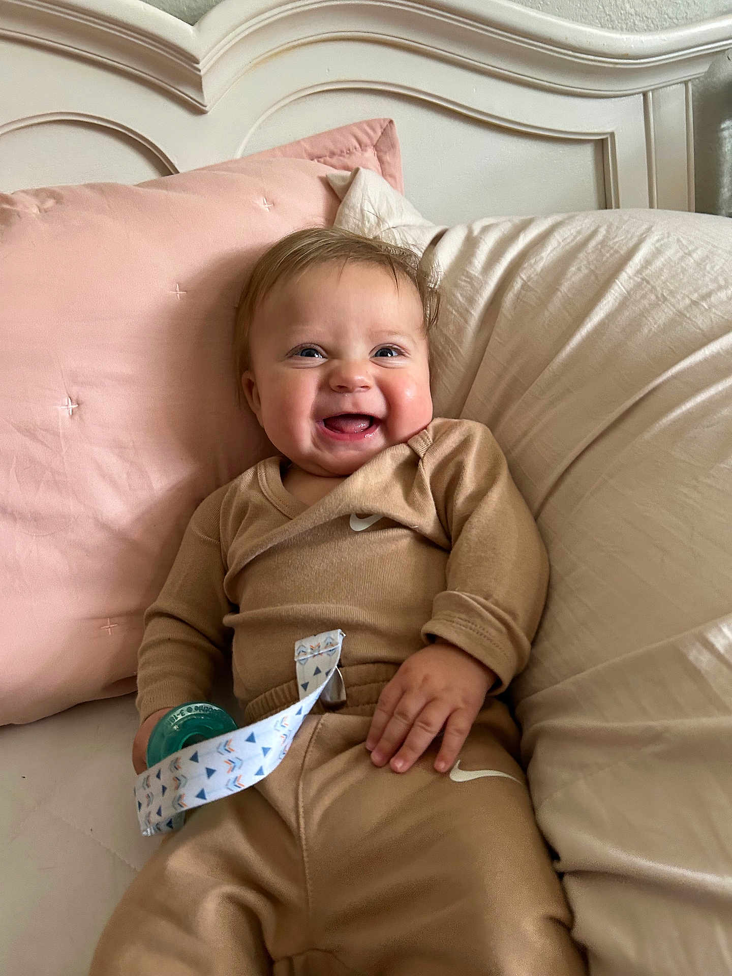Maverick is registered to the contest to win money with this photo: baby, smiling, pacifier, pillow, bed, clothing, infant, happy, person, indoors, cute, child, soft, relaxed, face, loungewear, hand, head, blanket, portrait