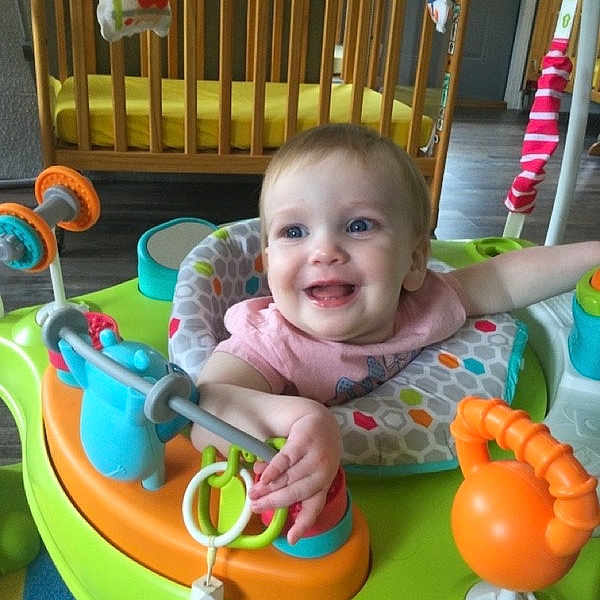 Caroline Marie is registered to the contest to win money with this photo: baby, smiling, child, activity_center, toy, indoor, crib, play, happy, infant, colorful, seat, floor, furniture, person, young_child, cute, development, joy, home
