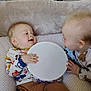 Maé participe au concours pour gagner de l'argent avec cette photo : baby, infant, tambourine, toy, playing, smiling, indoor, child, cute, pajamas, furniture, high_chair, blanket, couch, happy, face, head, hands, interaction, toddler