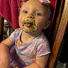 baby, child, infant, birthday, cake, frosting, sprinkles, messy_face, bow_headband, dress, colorful_clothing, sitting, chair, portrait, indoors, smiling, tongue_out, playful, close_up, family_photo