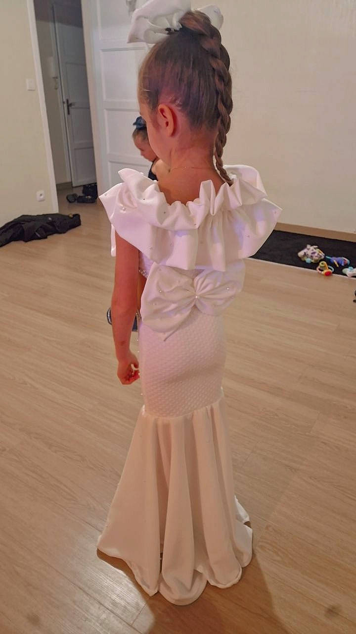 Ylianna a rejoint le concours — aidez-le/la à gagner de superbes lots ! baby_toddler_clothing, blond, day_dress, dress, fashion_design, floor, flooring, formal_wear, gesture, hardwood, human_leg, knee, neck, one_piece_garment, person, sleeve, toddler, trunk, waist, white