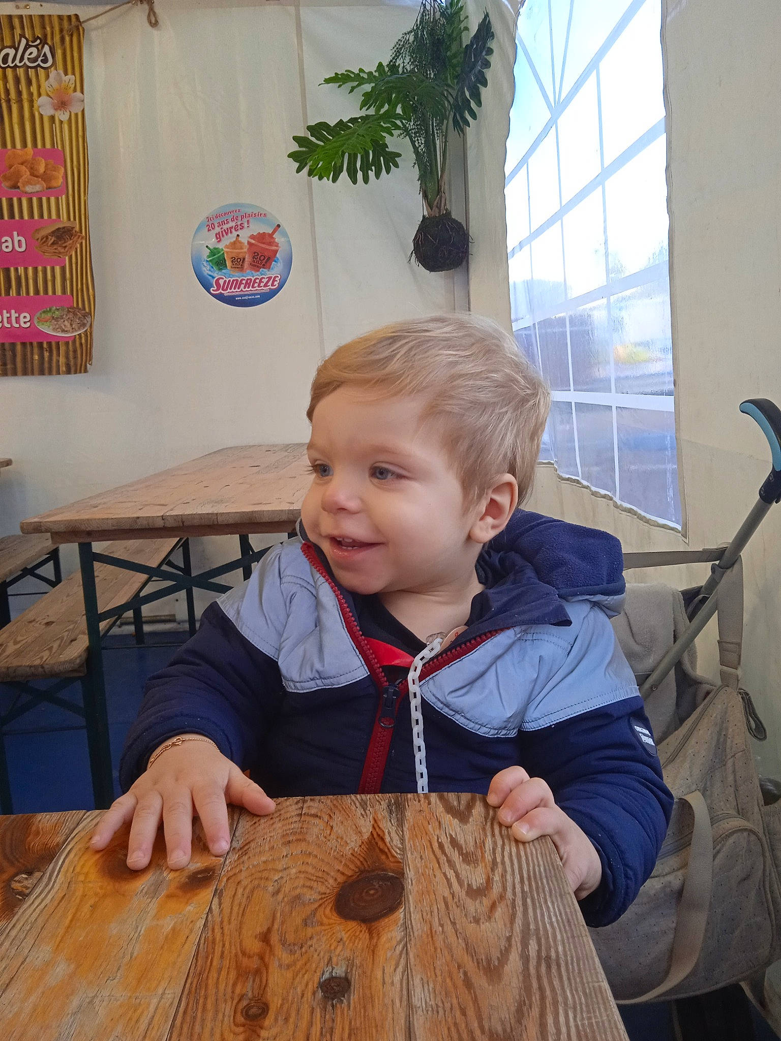 Tiago a rejoint le concours — aidez-le/la à gagner de superbes lots ! art, chair, floor, flooring, flowerpot, fun, hairstyle, hardwood, houseplant, jacket, joy, kitchen_dining_room_table, leisure, person, plant, smile, standing, table, toddler, varnish