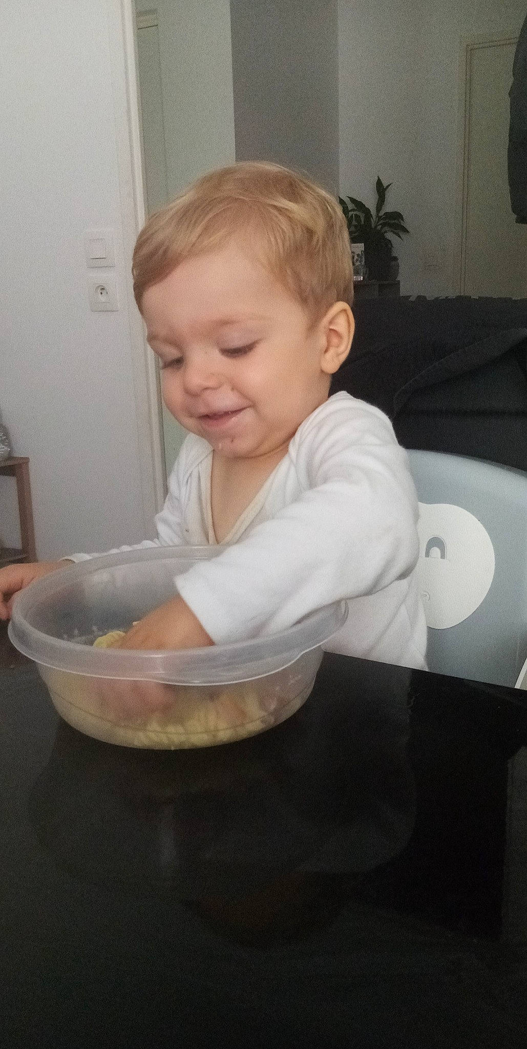 Tiago a rejoint le concours — aidez-le/la à gagner de superbes lots ! baby, baby_food, baby_toddler_clothing, bib, cheek, child, comfort, cooking, finger, flooring, fun, hand, houseplant, person, plant, product, sitting, sleeve, smile, tableware