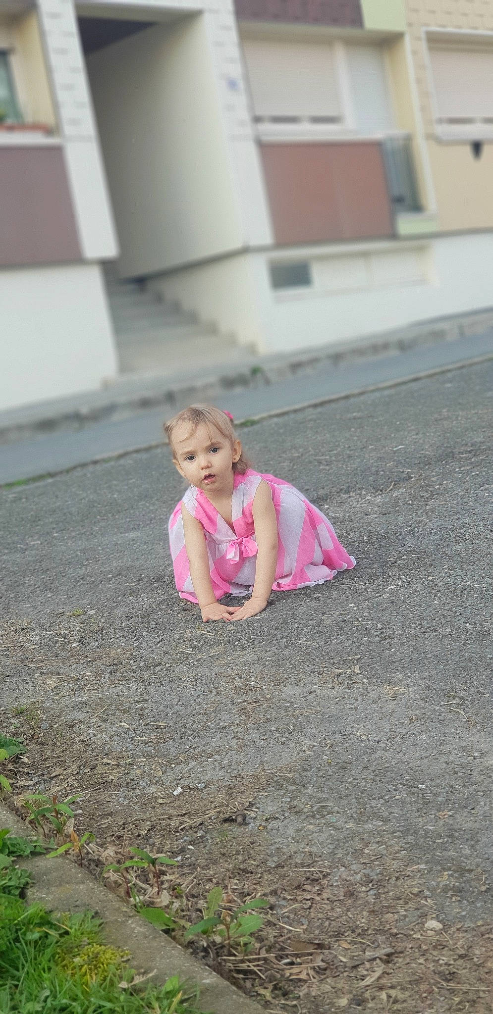 Hachley participe au concours pour gagner de l'argent avec cette photo : asphalt, child, driveway, fun, grass, person, photography, pink, plant, play, public_space, road_surface, sidewalk, sitting, summer, toddler, vacation