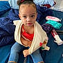 Nevaeh joined the competition — help win amazing prizes! bed, blanket, casual_clothing, child, curly_hair, cute, denim_jeans, face, home, human, indoor, looking_at_camera, pillow, red_top, relaxed, sitting, soft_lighting, sweater, toddler, young_child