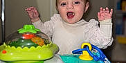 Madalynn is registered to the contest to win money with this photo: activity_center, baby, chewing, child, clothing, colorful, cute, face, furniture, hands_up, happy, headband, indoor, infant, person, playtime, smiling, toy, walker, young_child