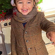 Louis participe au concours pour gagner de l'argent avec cette photo : child, christmas_tree, coat, corduroy, festive, gift_wrap, happy, holiday_decorations, indoor, ornament, pants, portrait, scarf, smile, smiling_child, sneakers, standing, teeth, toddler, wooden_floor