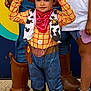 Louis a rejoint le concours — aidez-le/la à gagner de superbes lots ! bandana, brown_shoes, child, colorful_background, concrete_ground, costume, cow_print, cowboy_hat, footwear, jeans, kid, outdoor, person, playful, red_bandana, smiling, toy_story, vest, woody, yellow_shirt