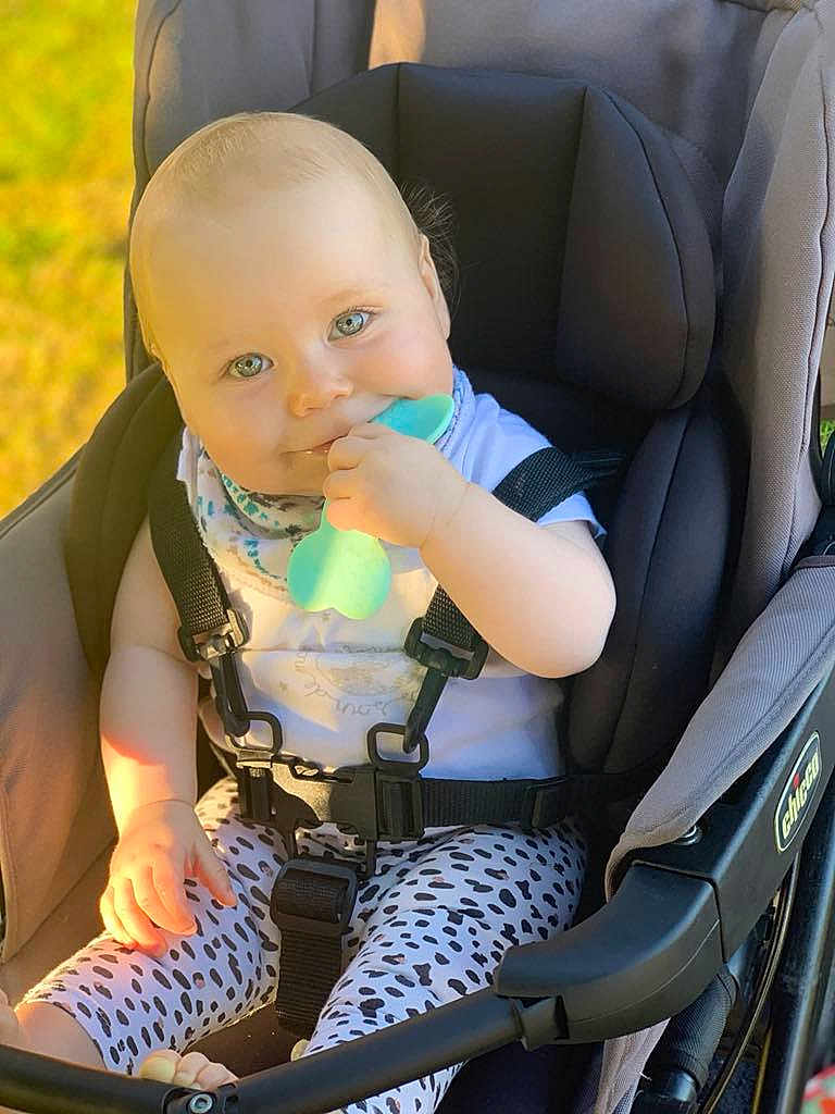 Hélyana a rejoint le concours — aidez-le/la à gagner de superbes lots ! baby, child, stroller, teething_toy, sitting, smiling, outdoor, daylight, clothing, harness, cute, infant, person, face, head, legs, footwear, playful, happy, accessory