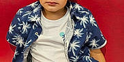Jules.e a rejoint le concours — aidez-le/la à gagner de superbes lots ! child, boy, portrait, casual_clothing, blue_shirt, white_tshirt, orange_shorts, red_couch, indoor, relaxed, young, sitting, short_hair, expression, fashion, comfortable, home, person, leisure, summer_style