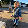 toddler, child, denim_jacket, boots, leopard_print, sidewalk, shadow, sunlight, outdoor, street, building, tree, casual_clothing, fashion, young_child, person, daylight, jeans, urban, cute