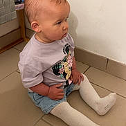 Rose a rejoint le concours — aidez-le/la à gagner de superbes lots ! toddler, child, sitting, floor, indoor, minnie_mouse, shirt, white_tights, shorts, hair, curious, side_view, baby, person, tile_floor, casual_clothing, young_child, small_hands, hair_loop, wall