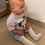 toddler, child, sitting, floor, indoor, minnie_mouse, shirt, white_tights, shorts, hair, curious, side_view, baby, person, tile_floor, casual_clothing, young_child, small_hands, hair_loop, wall