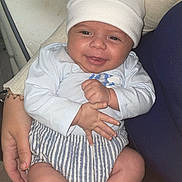 Maëlyo participe au concours pour gagner de l'argent avec cette photo : baby, casual, child, clothing, cute, face, hand, happy, hat, holding, indoor, infant, newborn, person, portrait, seated, skin, smiling, socks, striped_shorts