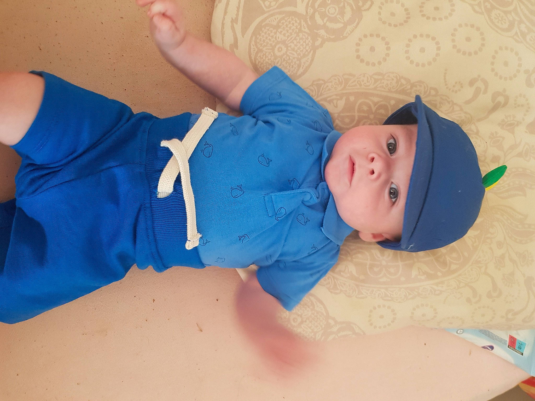 Ethan a rejoint le concours — aidez-le/la à gagner de superbes lots ! aqua, baby, baby_products, baby_toddler_clothing, child, comfort, elbow, electric_blue, facial_expression, finger, hat, headwear, knee, pattern, person, product, skin, sleeve, t_shirt, textile