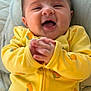 Layaal is registered to the contest to win money with this photo: baby, smiling, yellow_onesie, orange_prints, hands, clasped_hands, happy, infant, cute, lying_down, blanket, cozy, soft, closeup, portrait, child, indoors, face, joyful, expressive