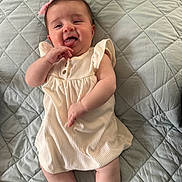 Layaal joined the competition — help win amazing prizes! baby, child, infant, smiling, tongue_out, dress, pink_bow, quilted_blanket, lying_down, cute, happy, skin, cheeks, arm, legs, indoors, person, portrait, playful, closeup