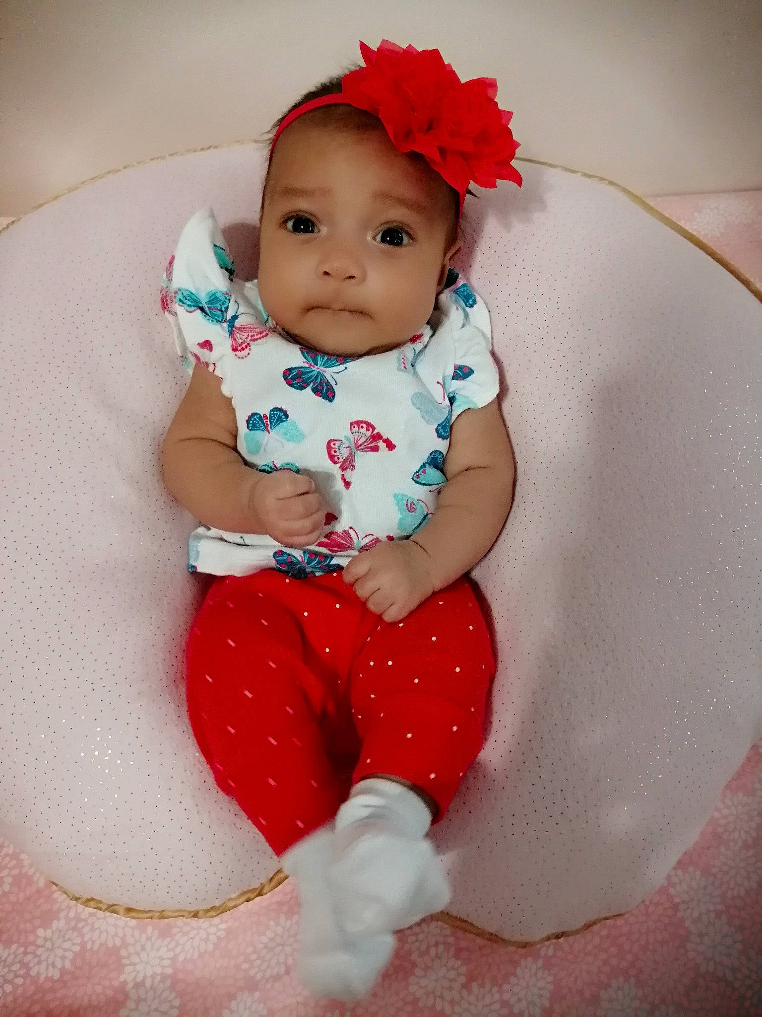 Tessa is registered to the contest to win money with this photo: baby, baby_toddler_clothing, child, fashion_accessory, hair_accessory, person, pink, red, sitting, skin, smile, toddler