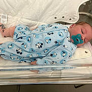 Lilio a rejoint le concours — aidez-le/la à gagner de superbes lots ! baby, newborn, pacifier, hospital, bassinet, onesie, mickey_mouse, clothing, sleeping, infant, child, pink_socks, blue_clothing, cute, resting, indoors, medical, blanket, soft, lying_down