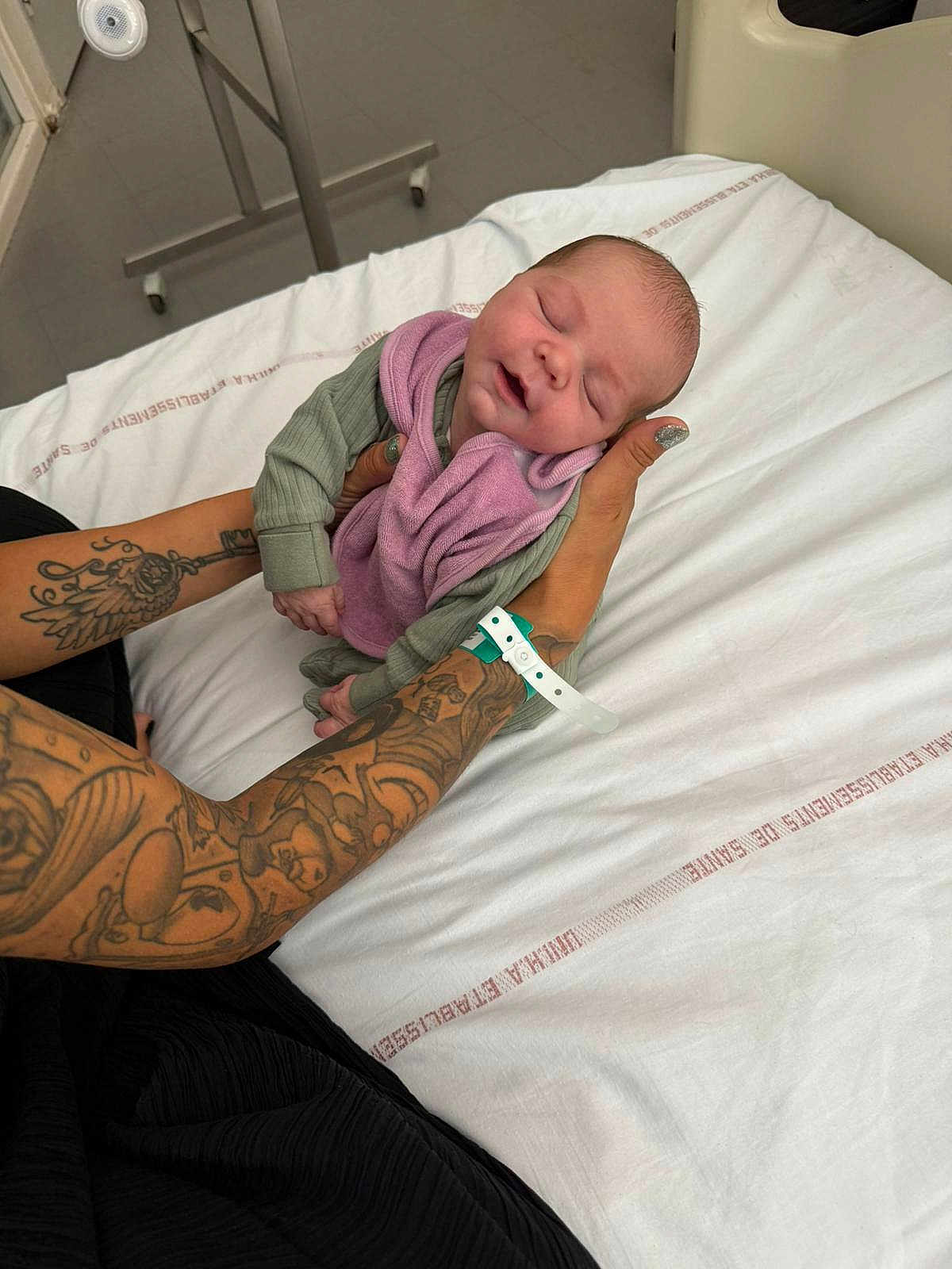 Lilio a rejoint le concours — aidez-le/la à gagner de superbes lots ! newborn, baby, tattoos, hospital, bed, blanket, infant, arms, wristband, sleeping, person, skin, hand, resting, clothing, napping, hospital_room, comfort, care, peaceful