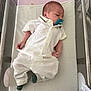 Lilio a rejoint le concours — aidez-le/la à gagner de superbes lots ! baby, newborn, pacifier, white_clothing, hospital_bassinet, infant, lying_down, green_socks, cute, sleepy, small_hands, small_feet, soft_blanket, indoors, resting, peaceful, human, portrait, young_child, infant_clothing