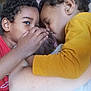 child, baby, toddler, love, affection, family, cuddle, closeup, head, face, hand, skin, curly_hair, yellow_clothing, red_clothing, indoor, intimate, tenderness, portrait, sibling
