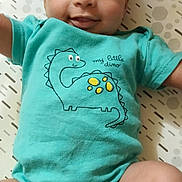 Ayani a rejoint le concours — aidez-le/la à gagner de superbes lots ! baby, infant, onesie, dinosaur_print, smile, lying_down, cute, child, patterned_background, happy, skin, arms, legs, clothing, young, person, indoors, soft_lighting, closeup, portrait